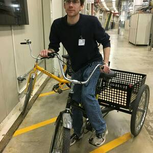 Jason Devlin rides bike at the APS synchrotron in 2018