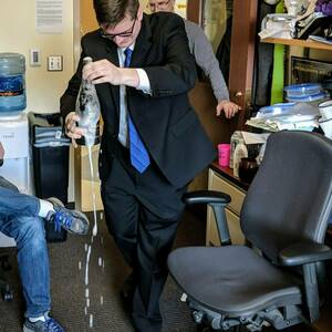 Cory Ayres opens champagne, celebrating after PhD defense in 2017