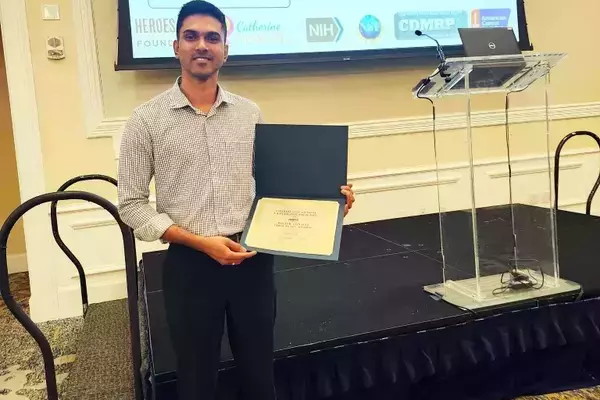 Photo of PhD student Gihan Perera with his award for best poster at the 2026 Harper Cancer Research Day